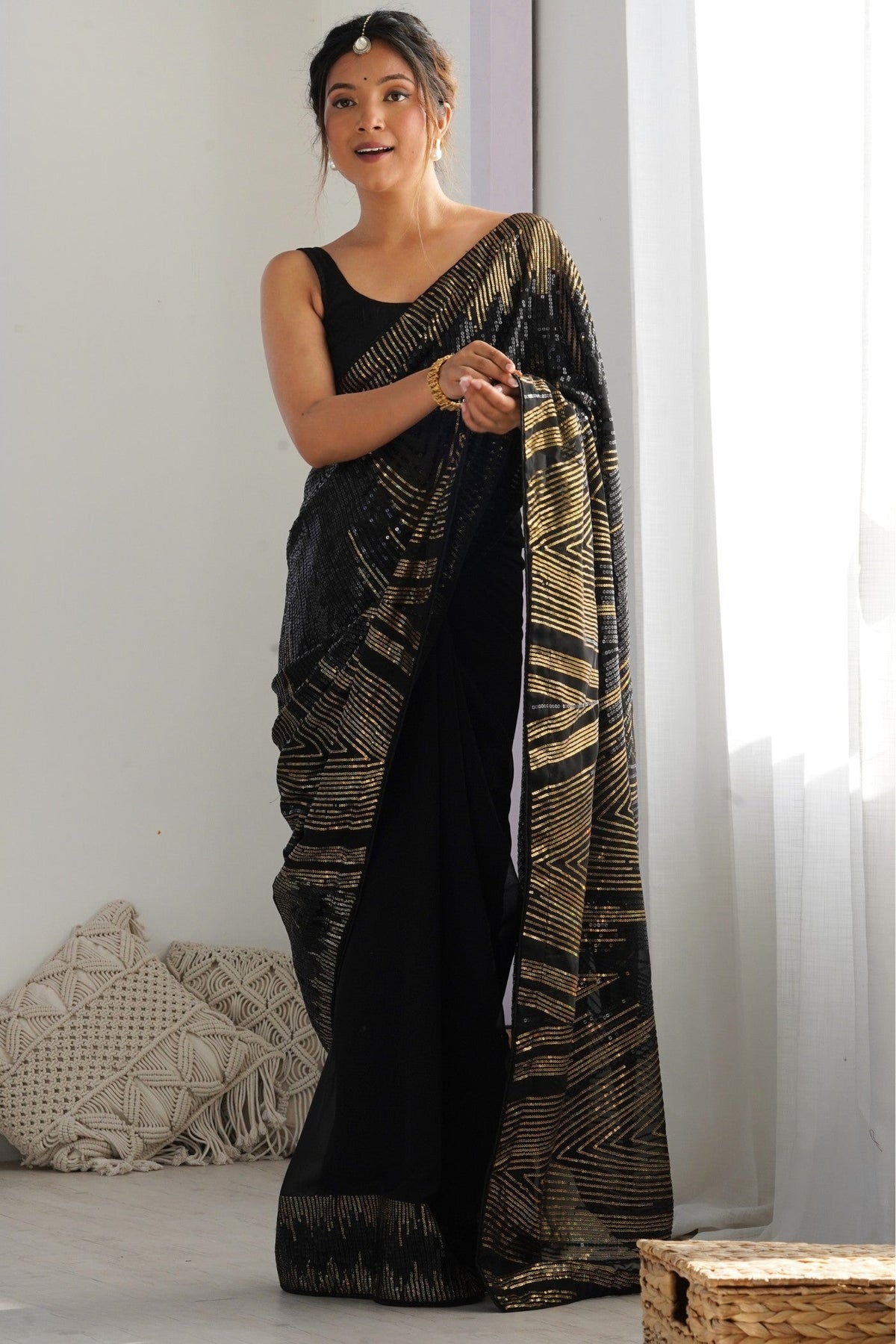 Model wearing a pitch black sequinned georgette partywear saree, the light fabric that suits a butterfly pallu drape
