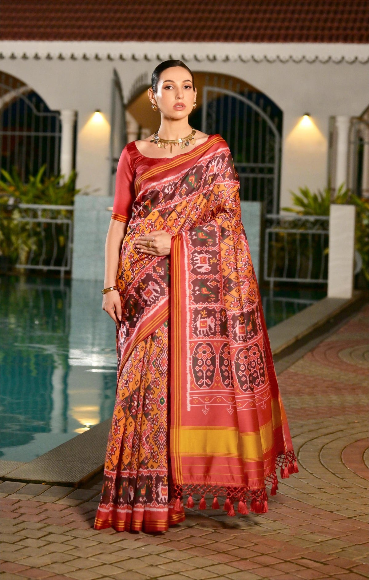 Neon orange printed Patola soft silk saree with multicolour ikat-style pattern and contrast pallu
