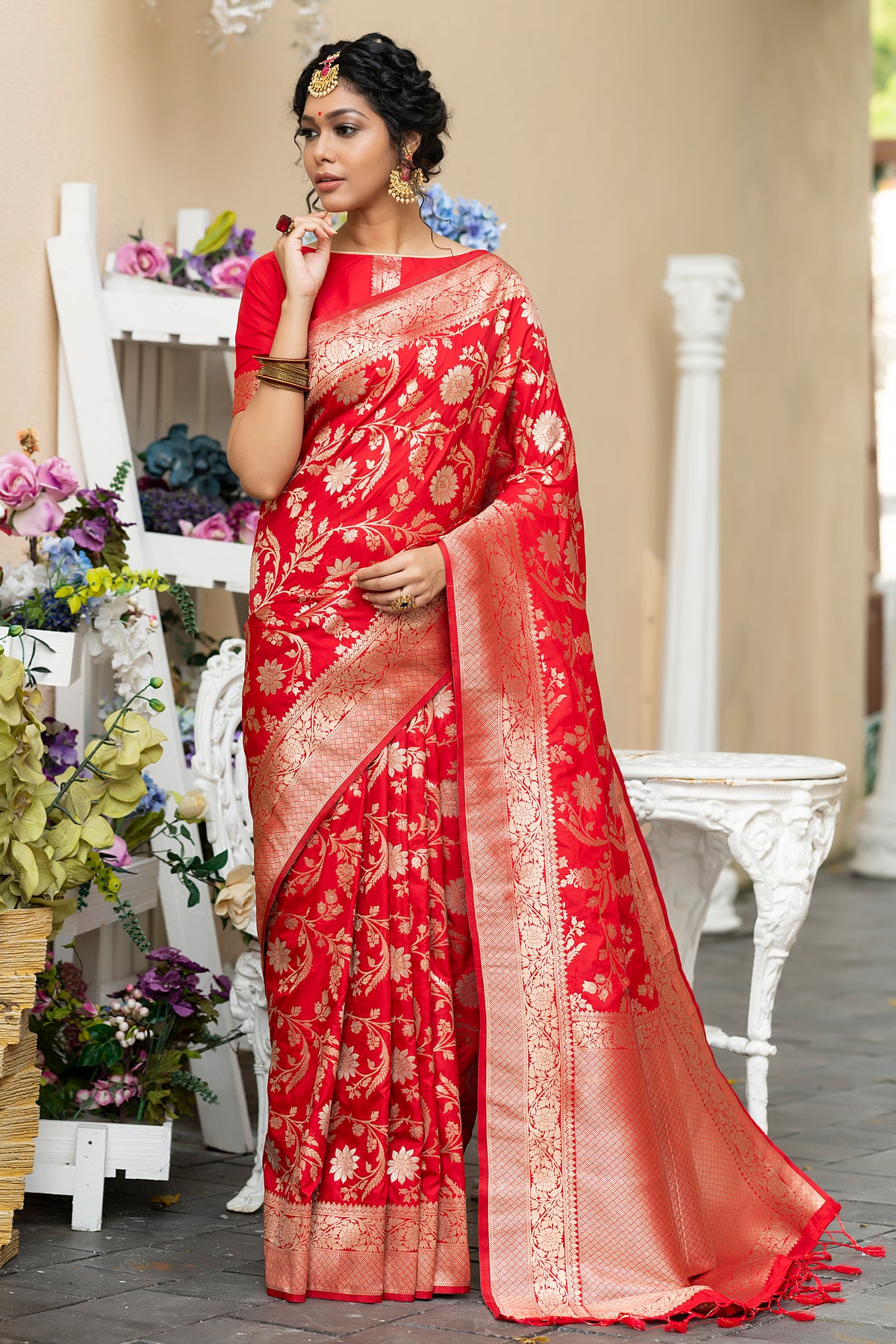 Woman wearing a Thunderbird red woven Banarasi silk saree with gold zari border, a classic Karva Chauth look for Delhi evenings